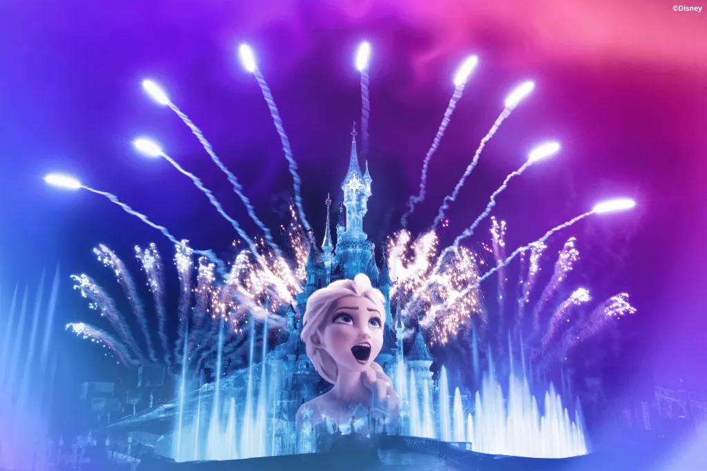 Disney Illuminations A projection of Elsa on Sleeping Beauty Castle with lights and fireworks in the background