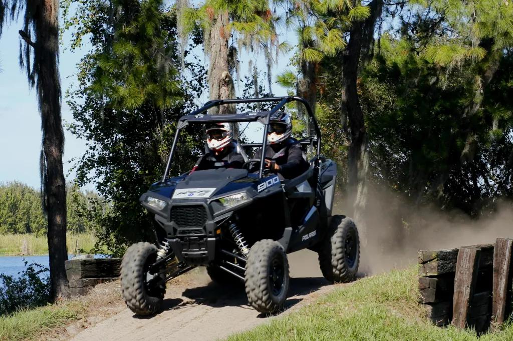 Can Am Buggy Two people in helmets sat next to each other in a 4x4 off road vehicle