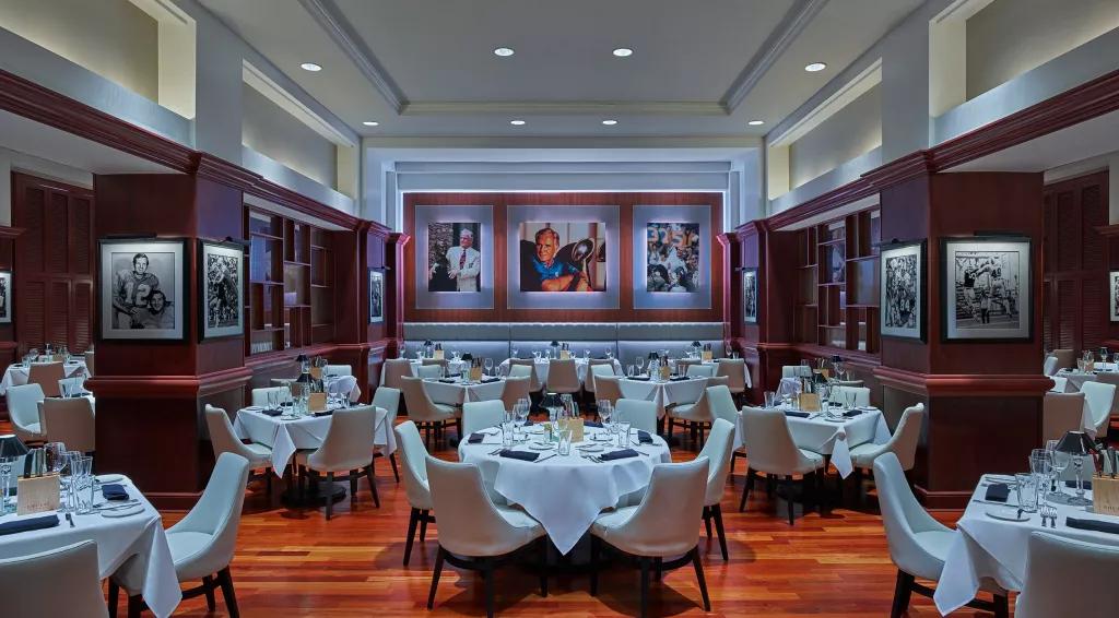 Shula's Steakhouse The dining room at Shula's Steakhouse, with multiple tables laid with linen table cloths and cutlery