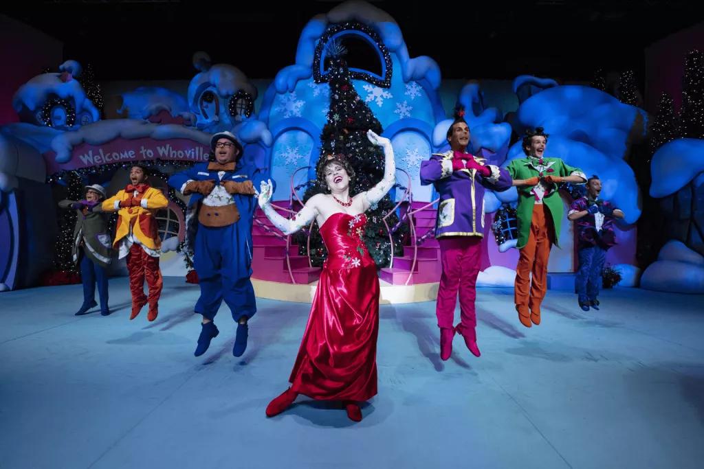Grinchmas Who-liday Spectacular Performers dressed up as Whos from The Grinch singing and dancing on a stage