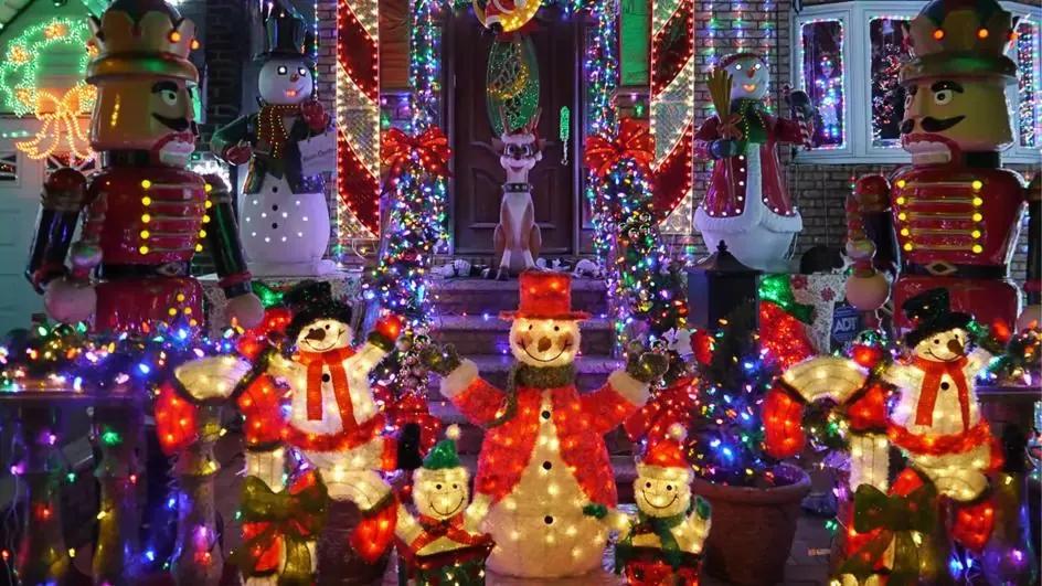 Dyker Heights Christmas Lights Light up Christmas decorations outside a house, including snowmen, nutcrackers and reindeer