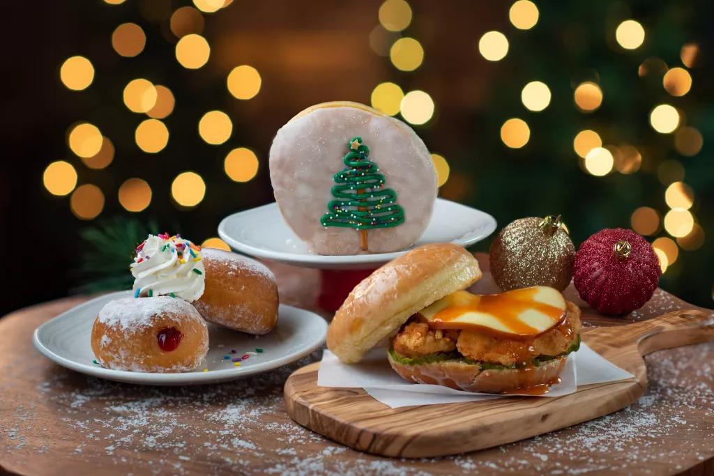 Seasonal Treats at SeaWorld Plates of food with a chicken sandwich and doughnuts in front of Christmas trees and lights