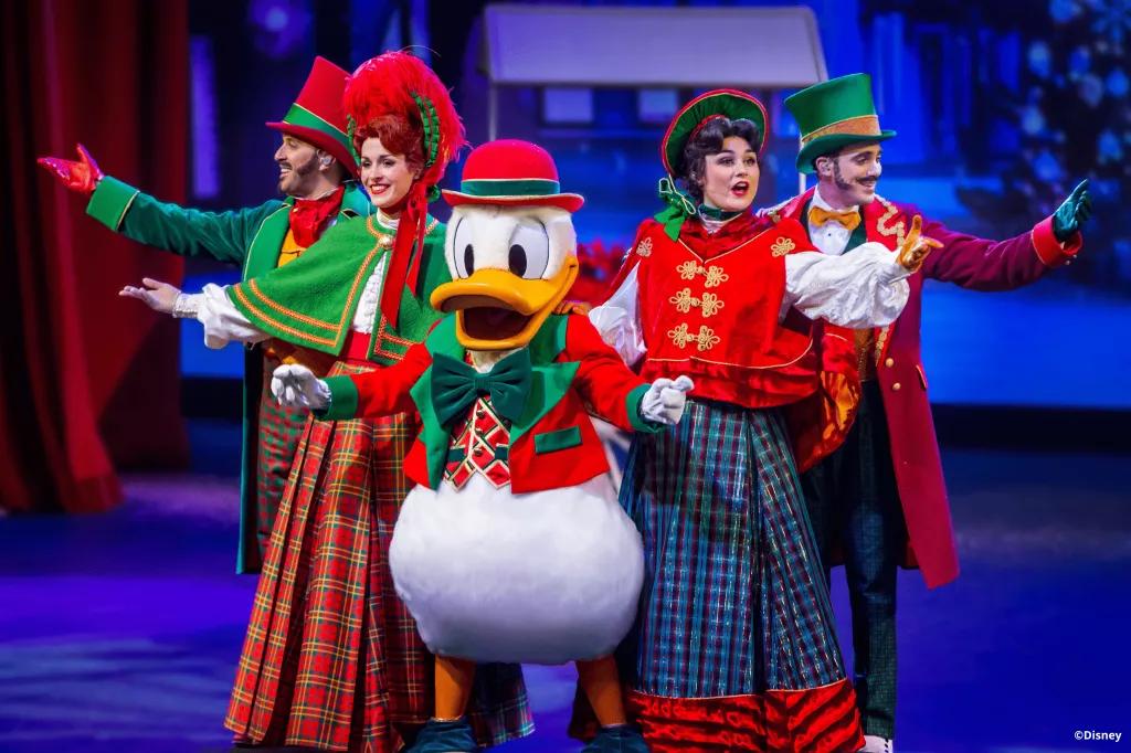 Let's Sing Christmas Donald Duck standing with four carol singers, all wearing Victorian style Christmas outfits