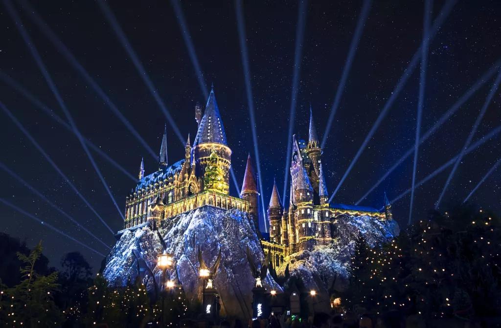 The Magic of Christmas at Hogwarts Castle Hogwarts Castle at night lit up with Christmas projections