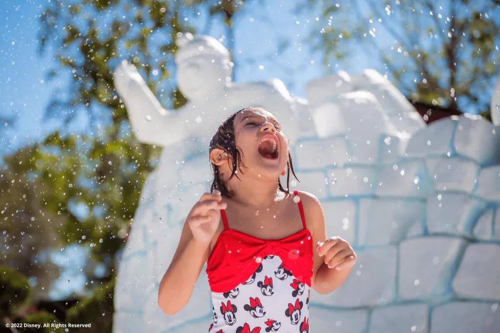Tike's Peak at Blizzard Beach Water Park A small girl in a Minnie Mouse swimming costume in front of a fake igloo in a water park