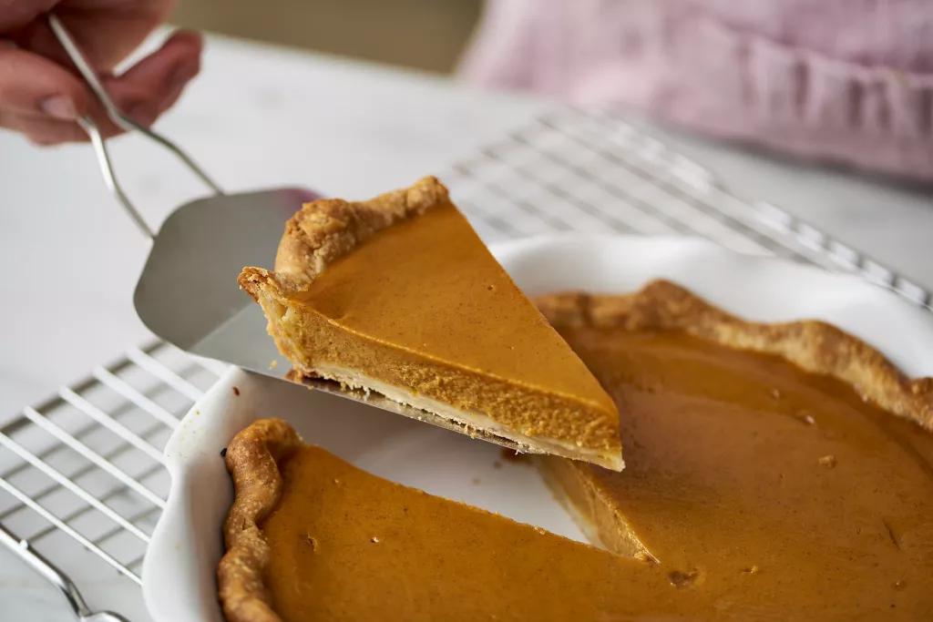 Pumpkin Pie A slice of pumpkin pie being lifted out of a pie tin