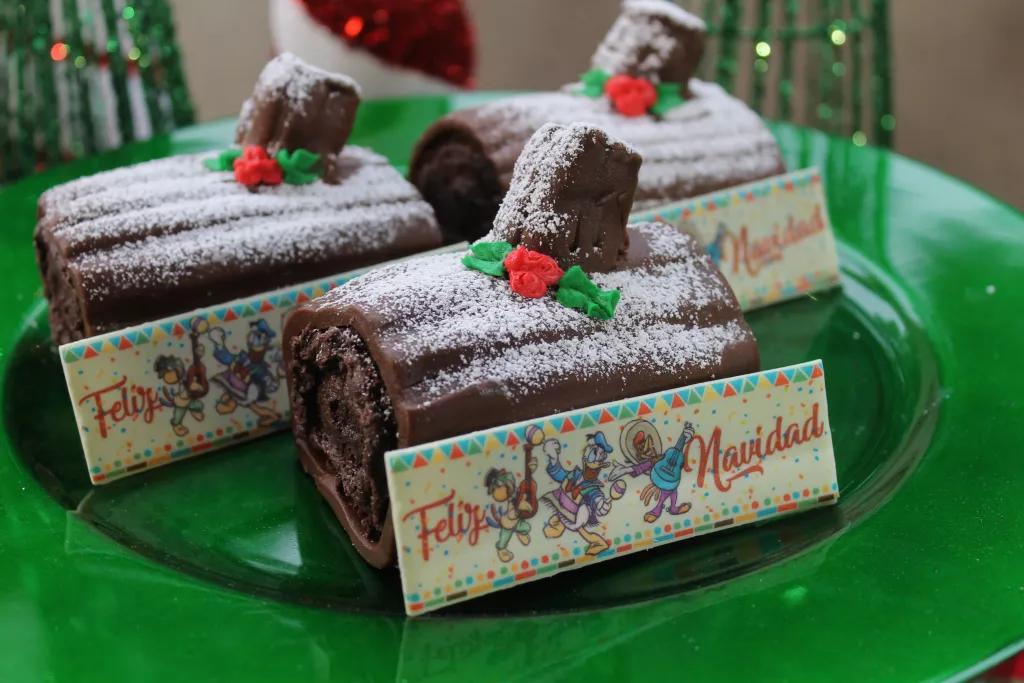 Festive Food at Walt Disney World Mini chocolate yule logs dusted with icing sugar, with a piece of chocolate that reads Feliz Navidad