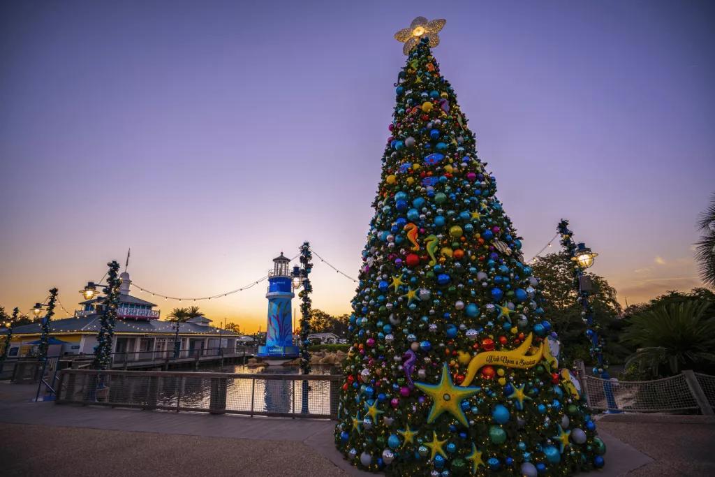 SeaWorld Christmas Celebration A decorated Christmas tree in front of the SeaWorld lighthouse while the sun is setting