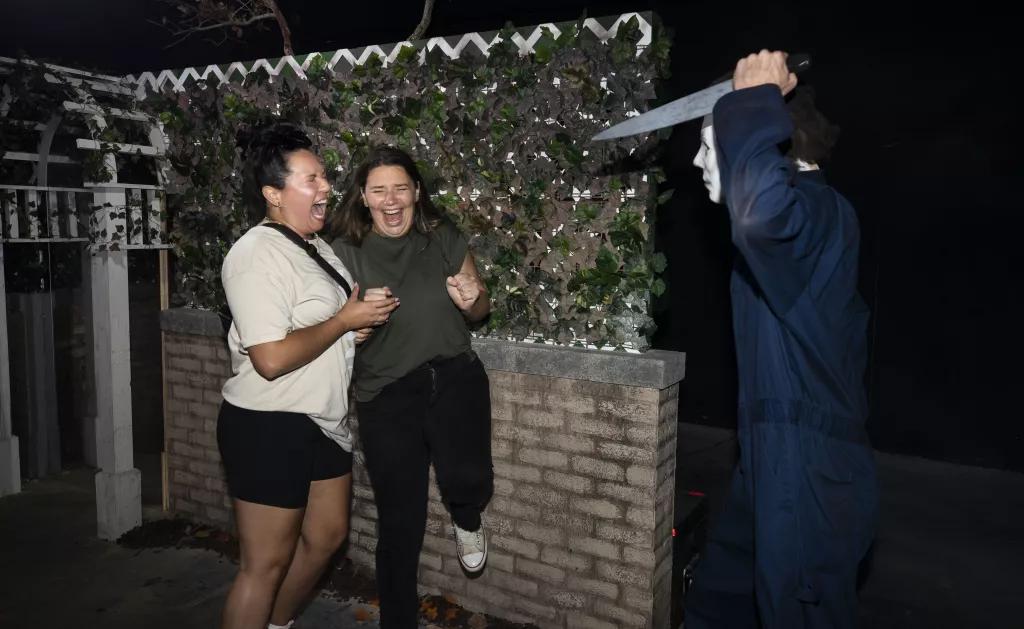 Halloween Horror Nights at Universal Orlando Resort Two women screaming while a scare actor jumps out at them with a knife