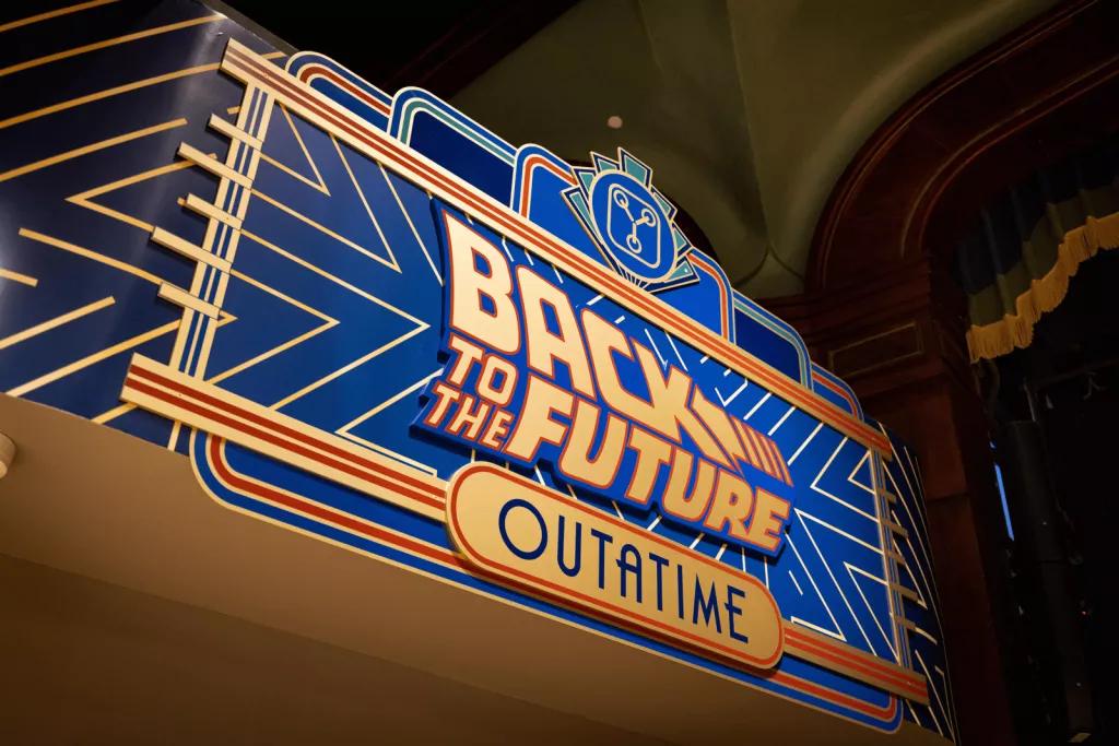Back to the Future OUTATIME An art deco style blue and gold sign that reads "Back to the Future - OUTATIME"
