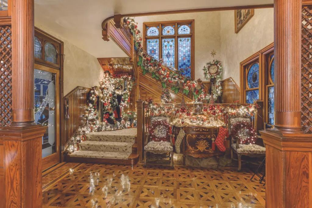 The Stetson Mansion at Christmas A large old fashioned staircase decorated for Christmas with stockings and garlands