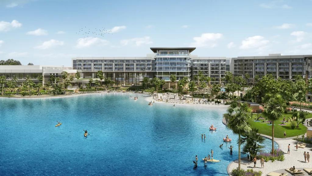 Conrad Orlando at Evermore A large modern hotel building behind a lagoon with a beach and palm trees