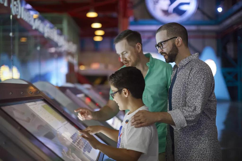 Interactive Activities at Kennedy Space Center A young boy and two men using an interactive touch screen