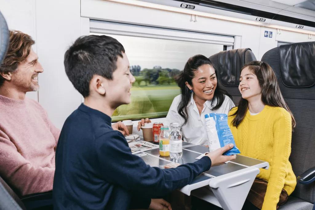 Dining on Eurostar A family of two adults and two children eating snacks on a Eurostar train