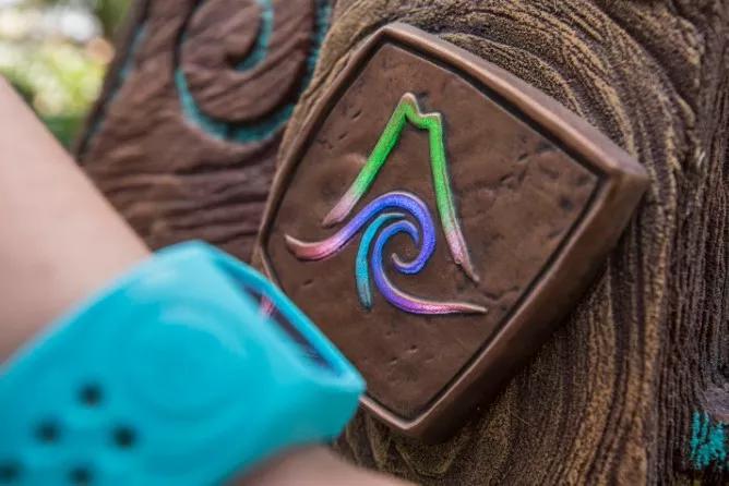 TapuTapu at Volcano Bay Some holding a bright blue 'TapuTapu' wristband to a 'TapTu Play' touch point