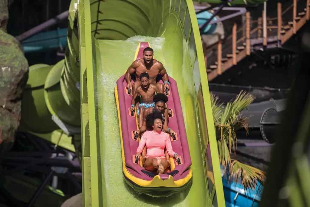 Krakatau Aqua Coaster Four guests in a raft screaming as they go down a drop on the Krakatau Aqua Coaster