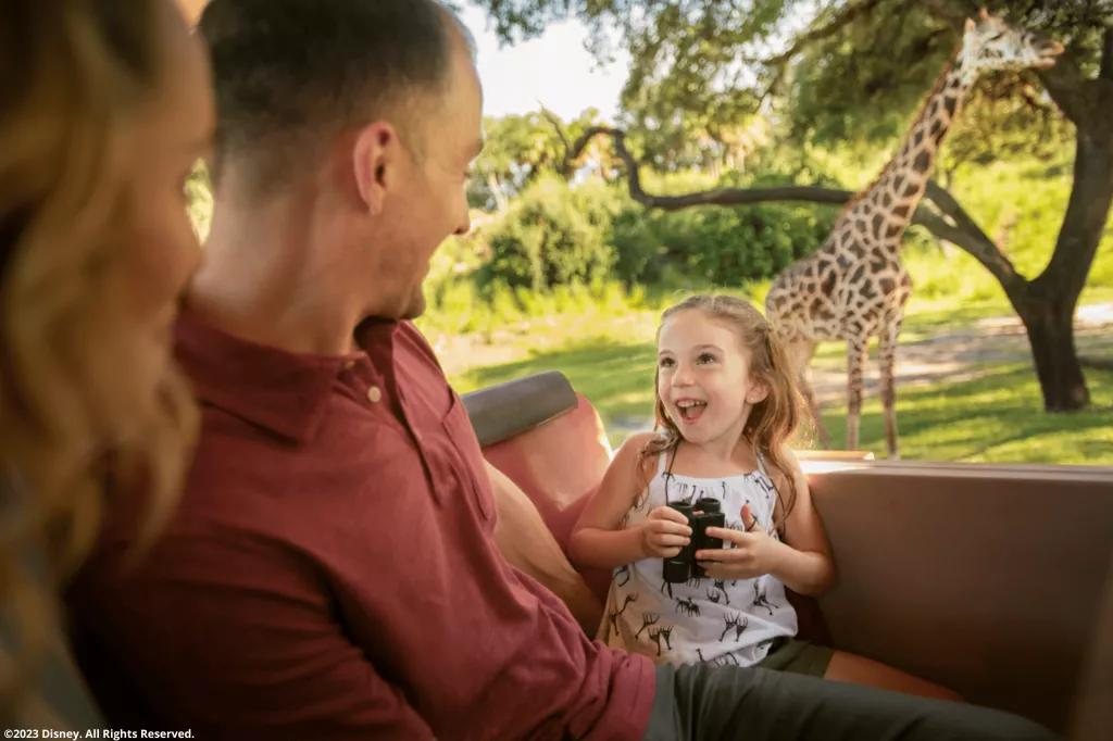 Gäste im Disney's Animal Kingdom Themenpark bestaunen eine Giraffe Gäste im Disney's Animal Kingdom Themenpark bestaunen eine Giraffe