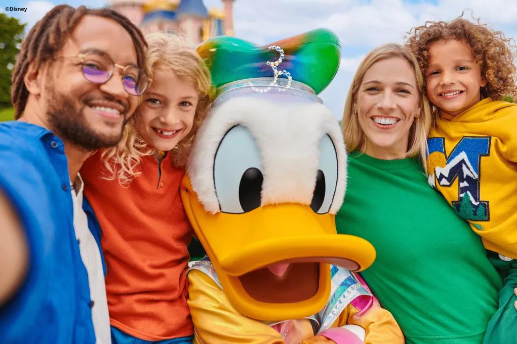 Two adults and two children taking a selfie with Donald Duck in his 30th anniversary costume