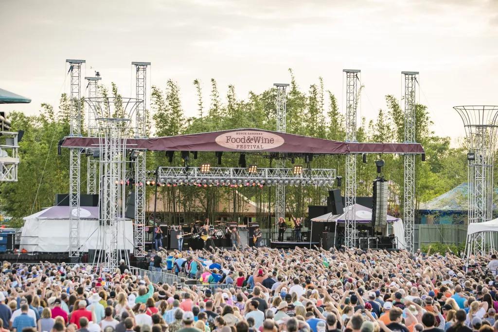 Food and Wine Concerts A large crowd of people watching a concert on an outdoor stage