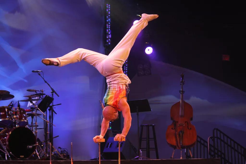 Acrobats at Festival of the Arts An acrobat on a stage doing a hand stand on two poles