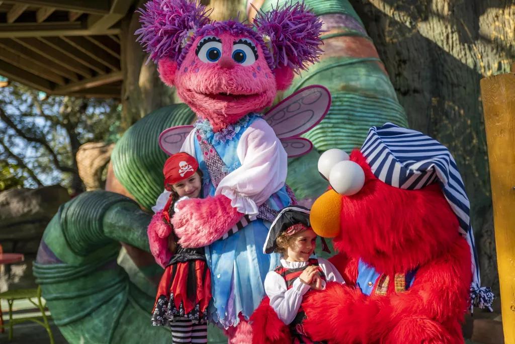Sesame Street Kids' Weekends Elmo and Abby Cadabby dressed as pirates hugging two young children
