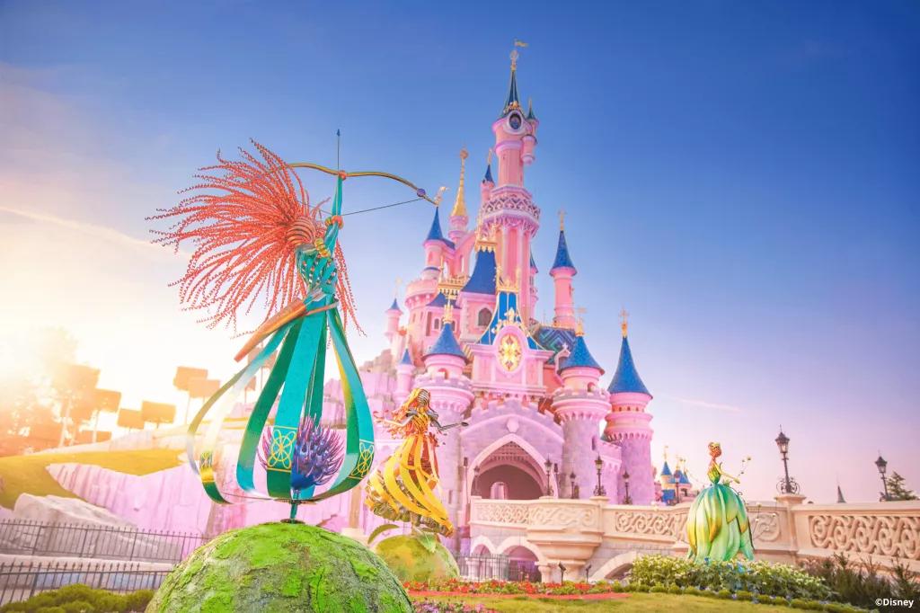 Gardens of Wonder An abstract metal sculpture of Merida holding a bow and arrow in front of Sleeping Beauty Castle