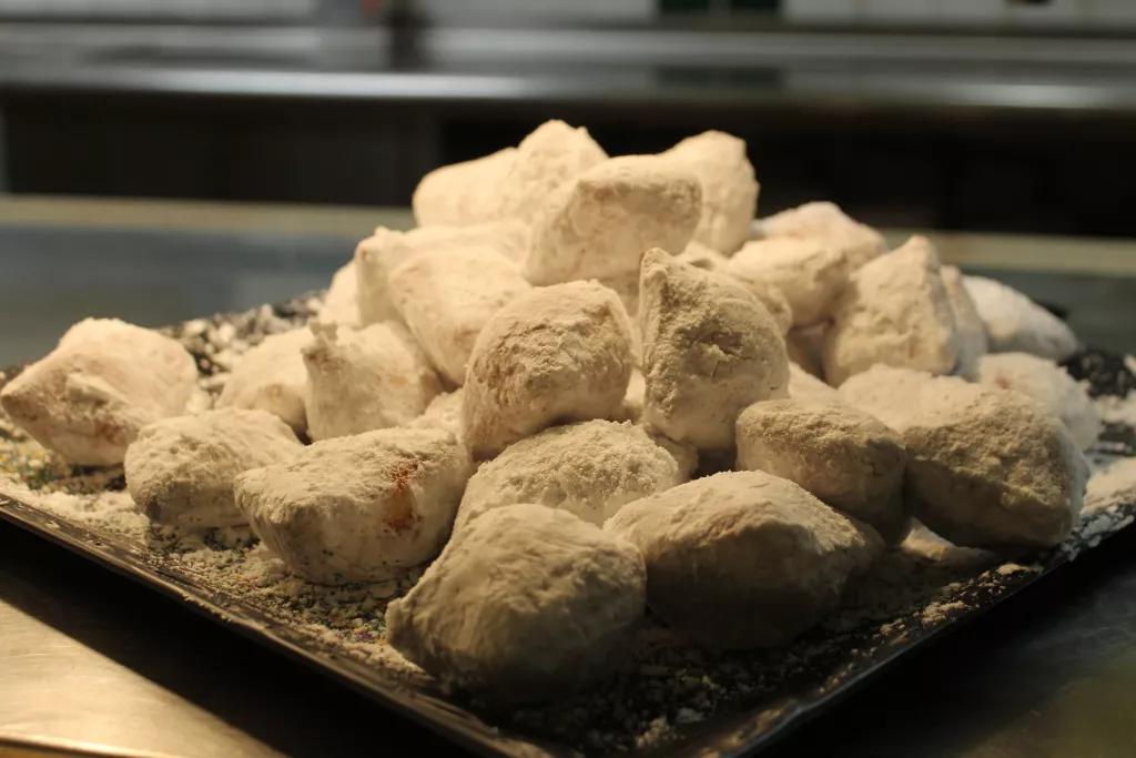 Beignets A large pile of beignets covered in powdered sugar