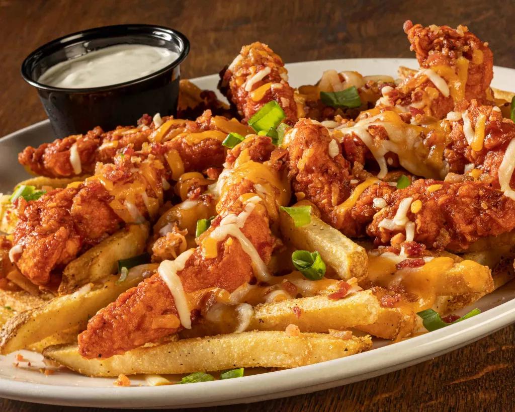Miller's Ale House Zingers A large plate of fries topped with breaded chicken tenders and cheese