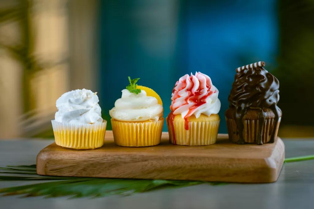 Sweet Sips 4 different flavoured cupcakes on a wooden board