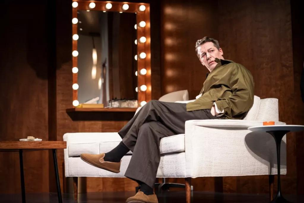 Good Night, Oscar An man sat on a white sofa next to a mirror, looking off into the distance
