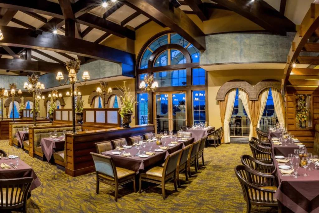 A Land Remembered The interior of a restaurant with lots of tables including booth seating in front of large arched windows