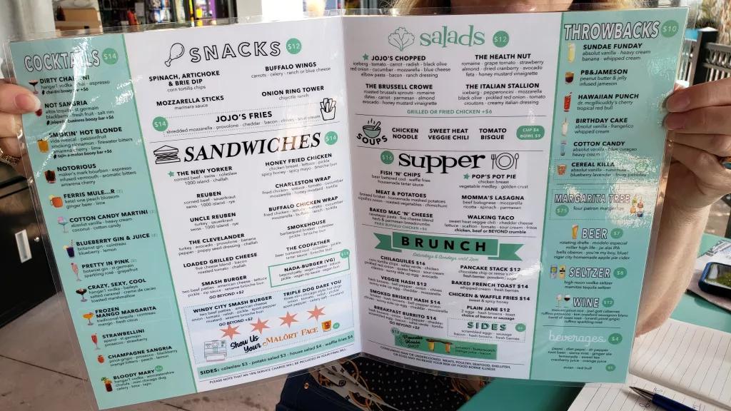 JoJo's ShakeBar Menu An open menu detailing the snacks, sandwiches, salads, dinner and brunch options available at JoJo's