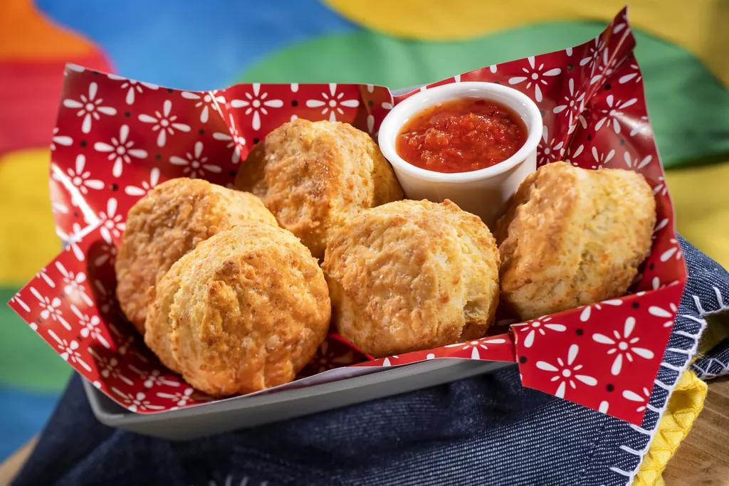 The Prospector's Cheddar Biscuits A basket full of cheddar biscuits with a ramekin of pepper jelly