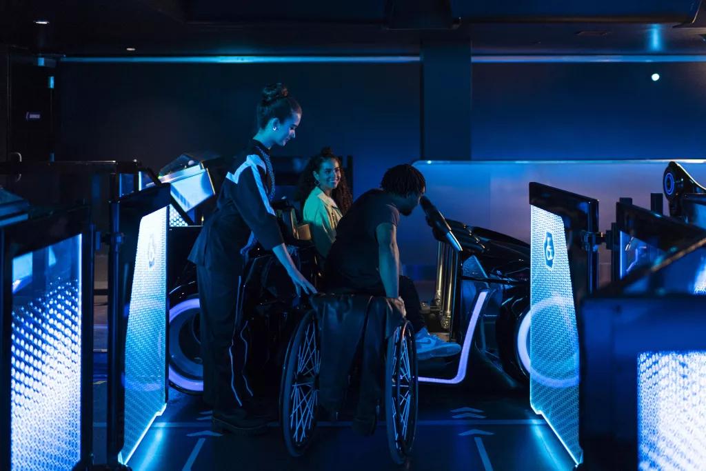 Accessible Ride Vehicles on TRON Lightcycle / Run A Cast Member helping a man out of a wheelchair into a TRON ride vehicle