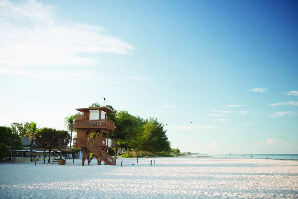 Bean Point Beach on Anna Maria Island A white sandy beach with greenery in the background and a wooden lookout