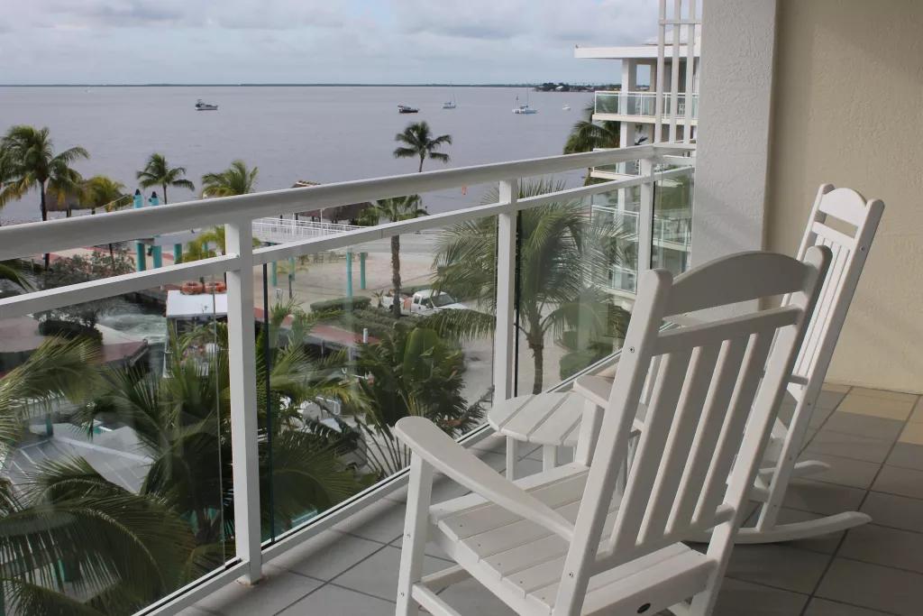 The Florida Keys Two white wooden rocking chairs on a balcony looking out over the ocean