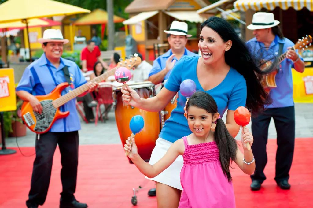 Viva La Musica at SeaWorld Orlando A young girl and a woman dancing in front of a band while shaking maracas