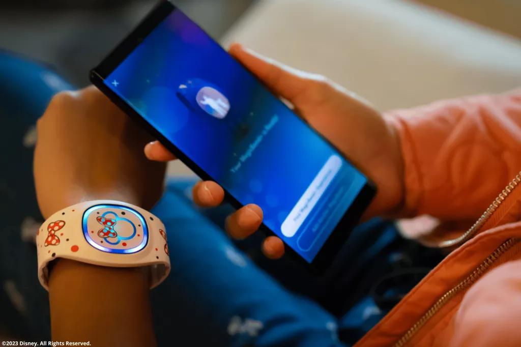 Disney Park Besucher mit Disney band und Disney Magic Mobile App Disney Park Besucher mit Disney band und Disney Magic Mobile App
