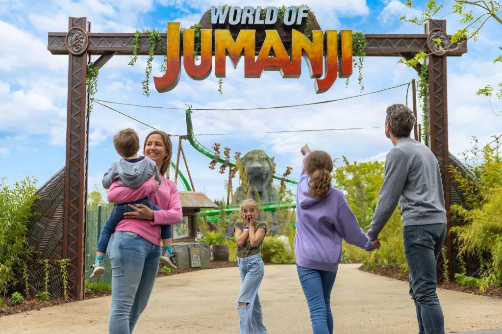 World of Jumanji A family standing in front of a sign reading World of Jumanji. One child is holding her face as if in shock
