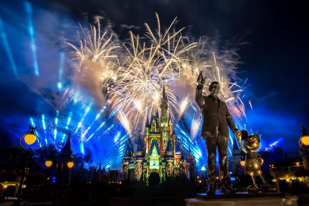 Fireworks at Walt Disney World Resort Fireworks going off over Cinderella Castle at Magic Kingdom behind a statue of Walt Disney and Mickey Mouse
