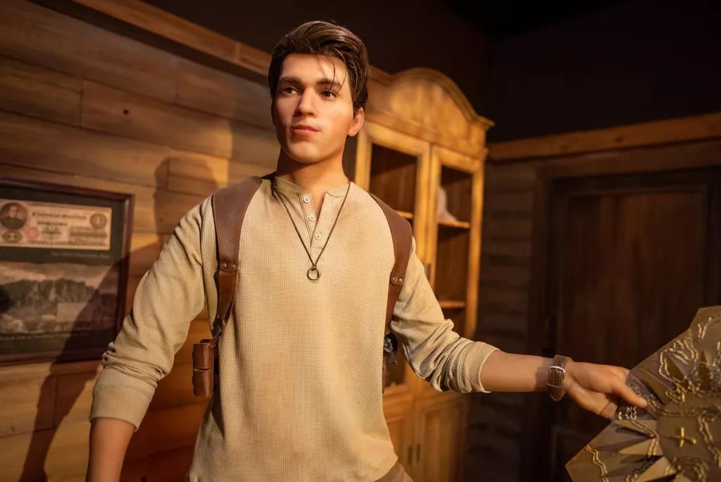 Uncharted Pre-Show A wax figure of a young man wearing a beige top and holding a map