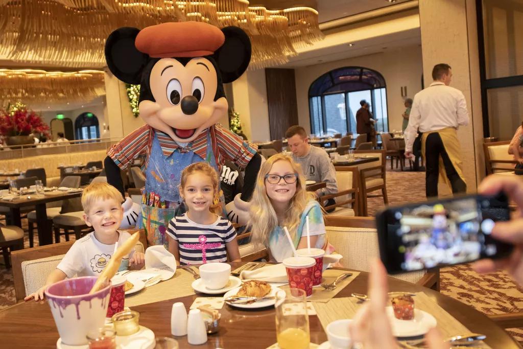 Breakfast at Topolino's Terrace Three children sat at a table with Mickey Mouse posing behind them