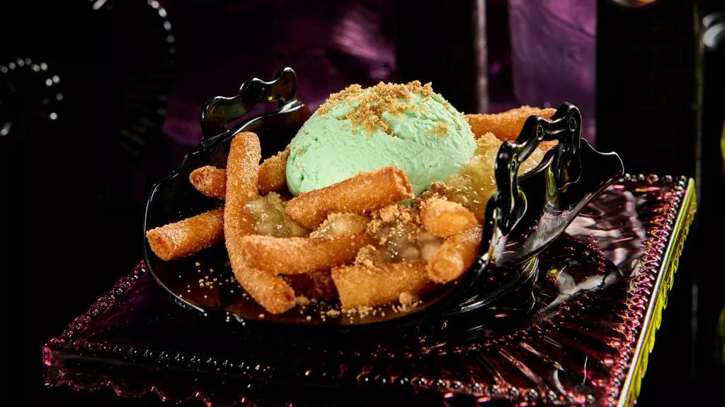 Sour Apple Pie Funnel Fries A plate of funnel cake fries topped with cooked apple and green apple ice cream