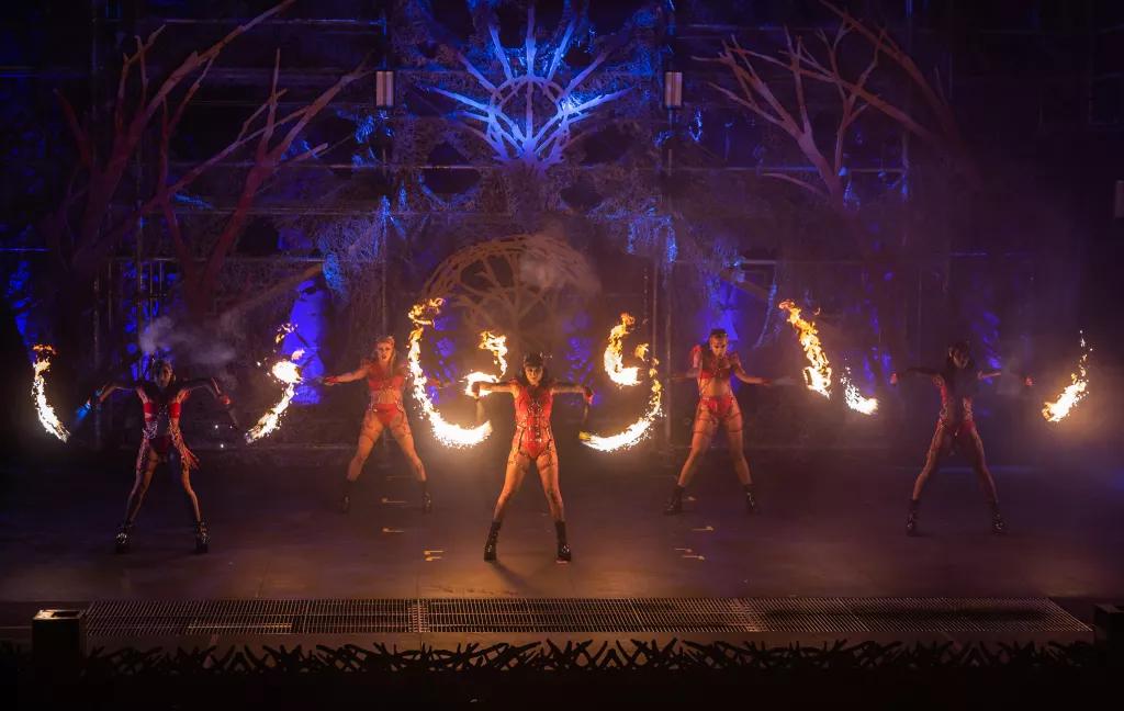 Nightmare Fuel Revenge Dream at Halloween Horror Nights Performers on a dark stage wearing leotards and twirling batons of fire