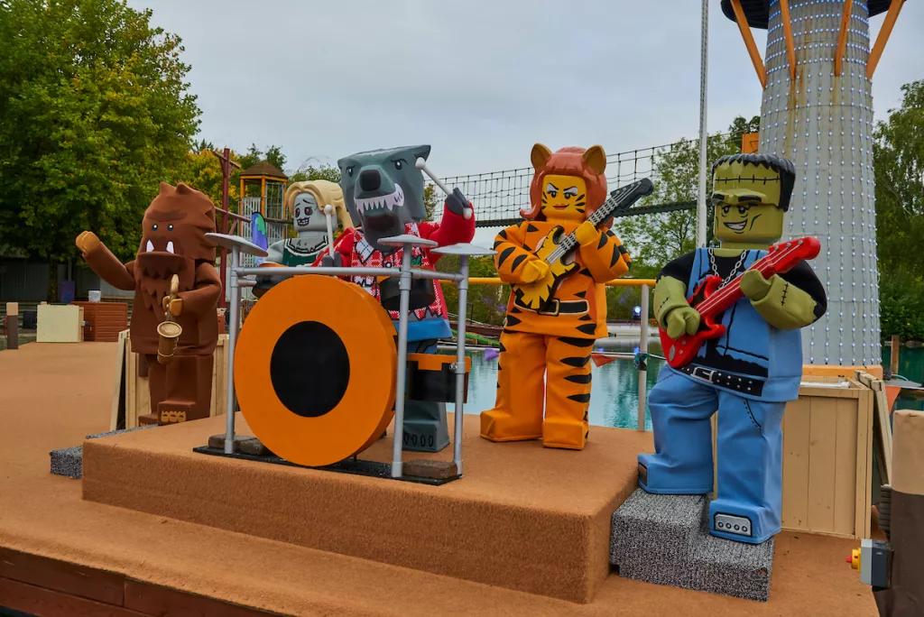 LEGO Monster Party People wearing Lego monster costumes standing on a stage playing pretend instruments