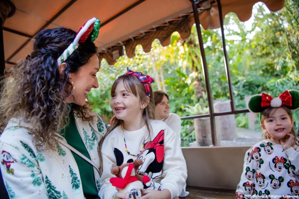 Jingle Cruise A family wearing Christmas outfits on a Jungle Cruise boat