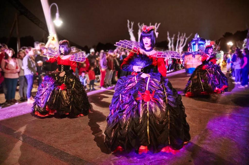 PortAventura Halloween Parade Parade performers dressed in large hooped dresses with spider details