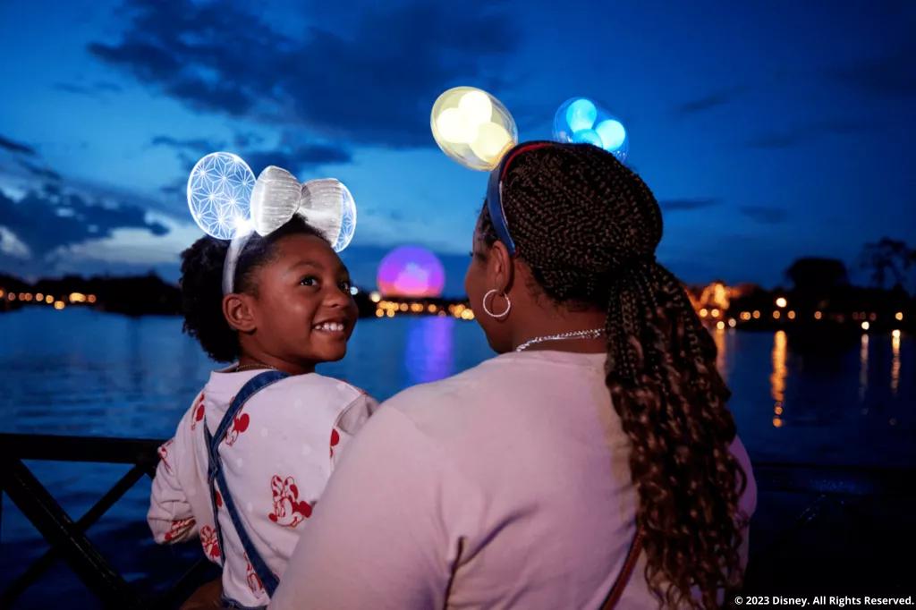 Disney After Hours in EPCOT Familie in EPCOT schaut über die Lagune und auf das beleuchtete Spaceship Earth
