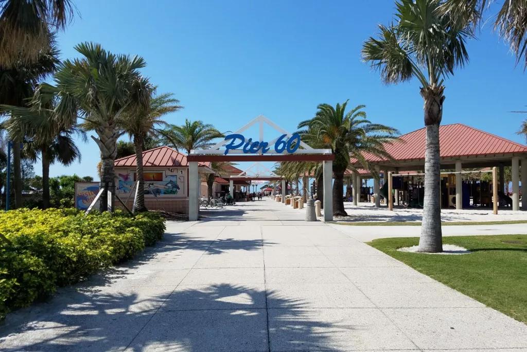 Pier 60 at Clearwater Beach A palm tree lined path leading up to an archway topped with a sing reading 'Pier 60'