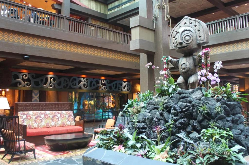 Disney's Polynesian Resort A tiki statue on top of a rock and flower formation in the middle of a hotel lobby